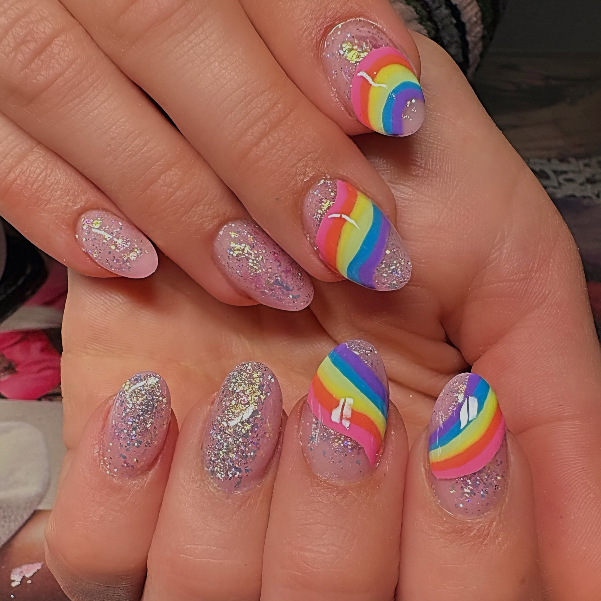 Ronde nagels met roze glitter en regenbogen in nail art